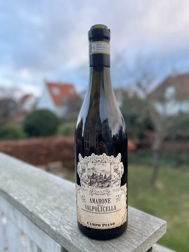 Amarone Valpolicella flaske med italiensk landbygård baggrund