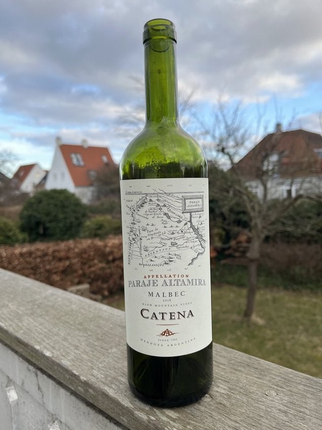 Catena Malbec vinflasje foran landlig hus