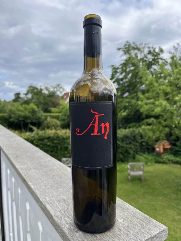 Flaske rødvin med rødt 'Arp' logo på terrasse