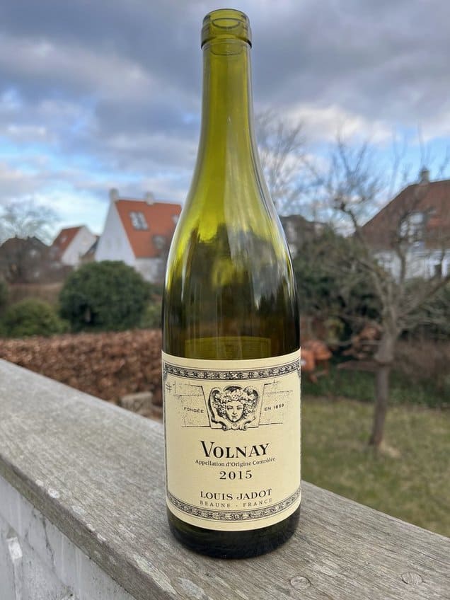 Volnay 2015 rødvinsflaske fra Louis Jadot foran landsbyhuse